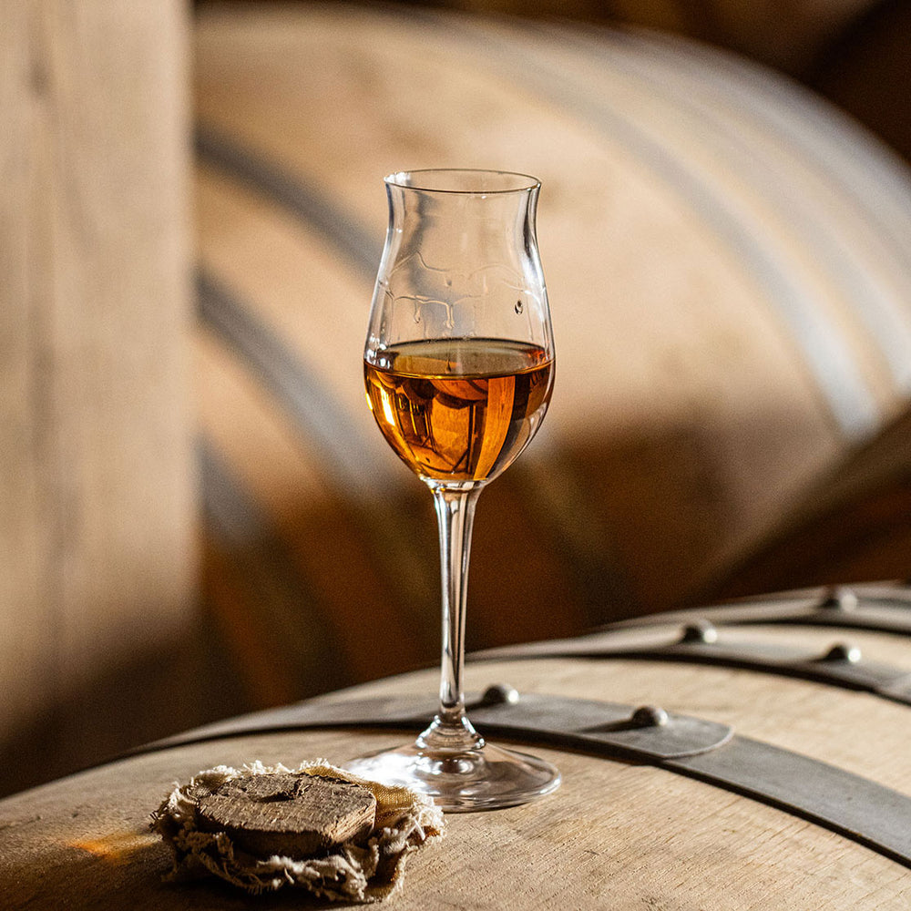 A Brandy glass over oak barrels