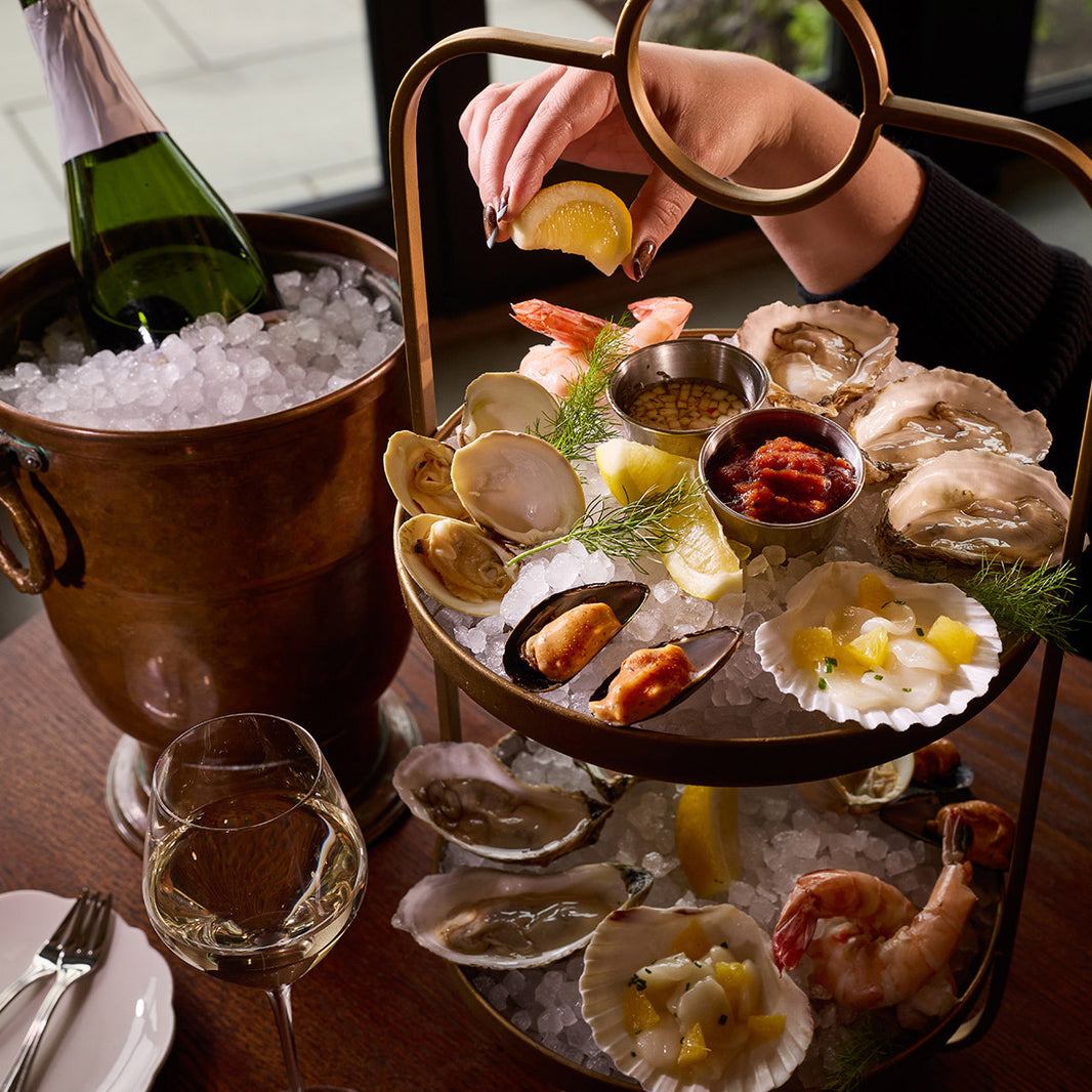 Seafood plateau with oysters and shellfish on ice with wine glasses