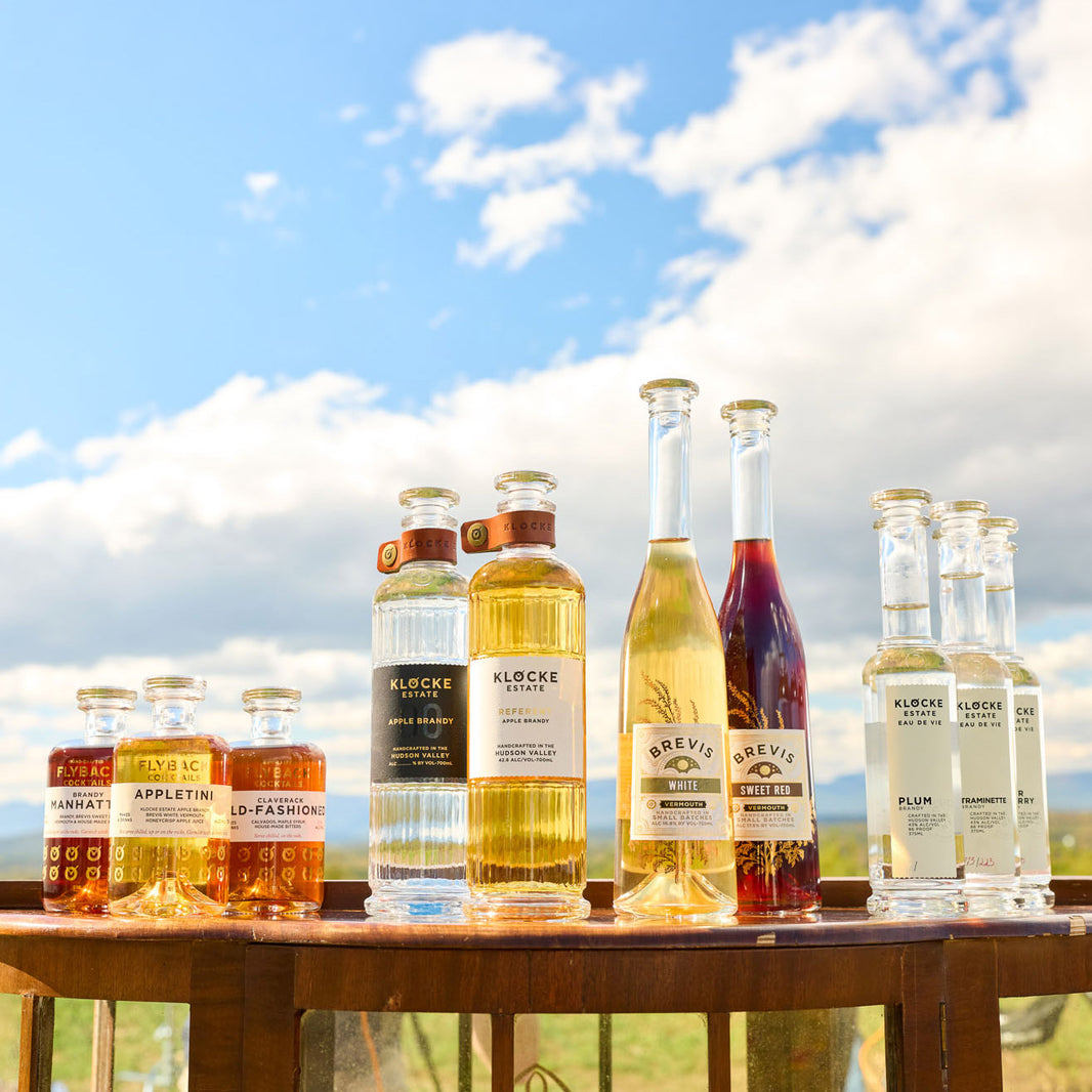 Bottles of Klocke Estate brandy and vermouth arranged on wooden surface